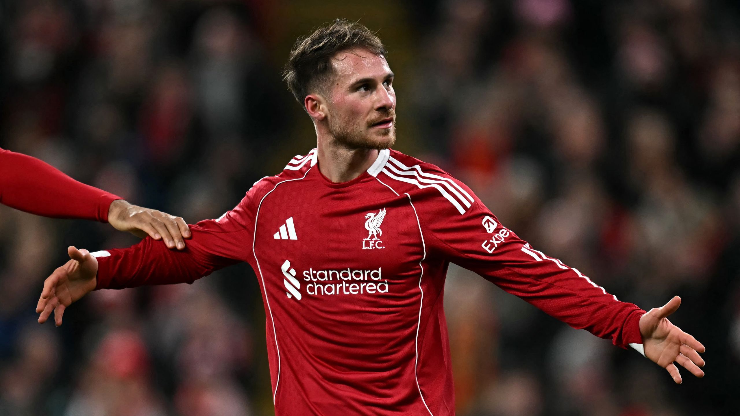 Alexis Mac Allister celebrating in a Liverpool home shirt at Anfield